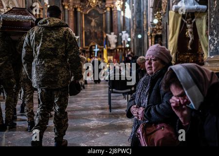 Lviv, Ukraine. 4th Apr, 2022. Two women cry while soldiers enter carrying a coffin of a dead soldier killed by the Russian army at the church of Saint Peter and Paul Garrison. Lviv military funeral.Russia invaded Ukraine on 24 February 2022, triggering the largest military attack in Europe since World War II. (Credit Image: © Rick Mave/SOPA Images via ZUMA Press Wire) Stock Photo