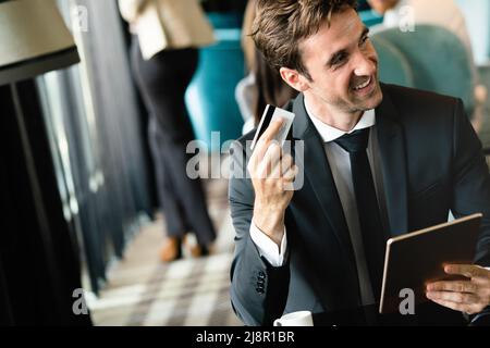 Portrait of happy successful businessman holding tablet Stock Photo