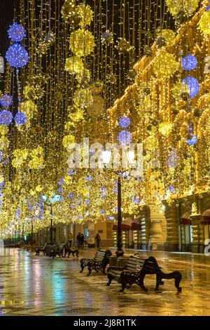 Moscow, Russia, Febrary 12, 2020: Golden colorful rain of Christmas decorations hanging from the sky, on Nikolskaya street next to GUM in the capital. Stock Photo