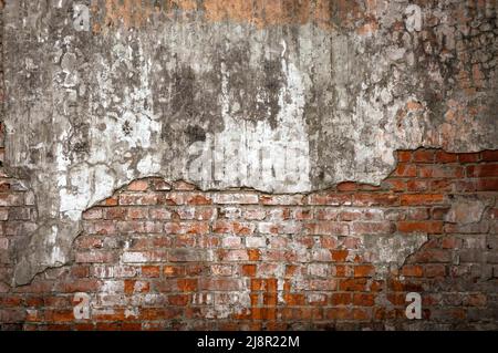 Old brick wall in a background image. Plastered Brickwall With Chipped Stucco Pieces. Red Textured Brick Wall With Damage Surface. Old Grunge Abstract Stock Photo