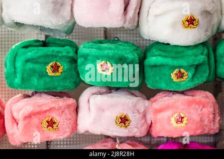 Moscow, Russia - November 27, 2019: Earflaps fur caps with red stars in a souvenir shop in Moscow. Winter hats, soviet and russian military uniform, t Stock Photo
