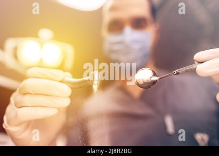 Professional male dentist with dental instruments working in dental clinic Stock Photo