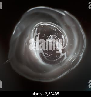 Cream gel transparent cosmetic sample texture with bubbles isolated on black background. Cosmetic cream transparent gel serum texture with micro Stock Photo
