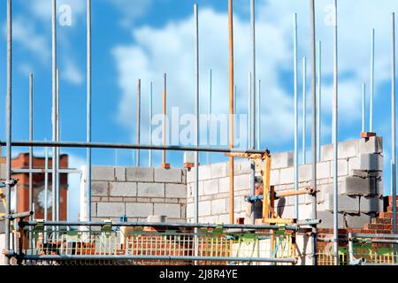 Scaffold installed around houses to provide access for bricklayers and other trades on construction site Stock Photo
