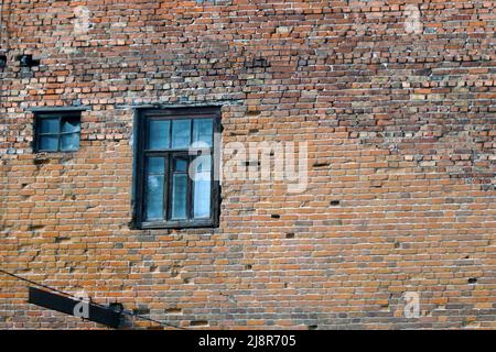 An abandoned old window in a dirty red brick wall Stock Photo