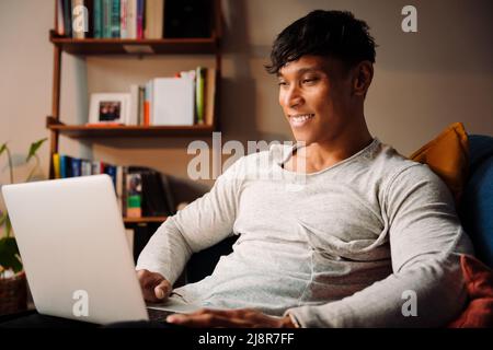 Asian male working on laptop at home Stock Photo