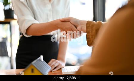 Female property investor shaking hands with female realtor or real estate agent in the meeting. Female real estate broker greeting her potential clien Stock Photo
