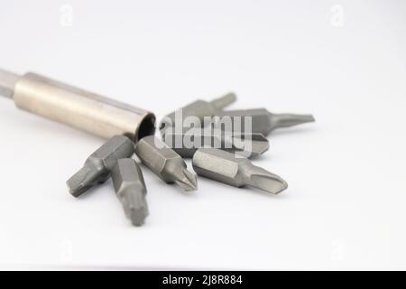 Drill bits of various shapes along with a screwdriver head on white background Stock Photo