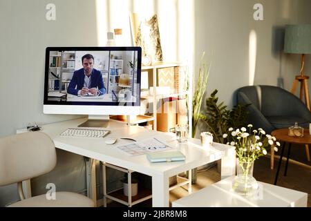 Modern desktop computer with paused video of successful businessman on screen in comfortable office interior Stock Photo