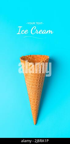 Crispy waffle cone on a blue background close-up. Top view, vertical. Stock Photo