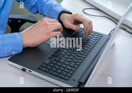 Close up of mans hand typing on laptop keyboard, businessman programmer working concept Stock Photo