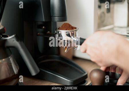 barista holding tamper near portafilter with grinded coffee, espresso, manual  press Stock Photo by LightFieldStudios