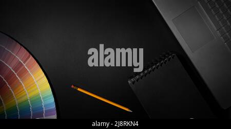 designer workspace with color swatch, laptop and notepad on black background. banner with copy space Stock Photo