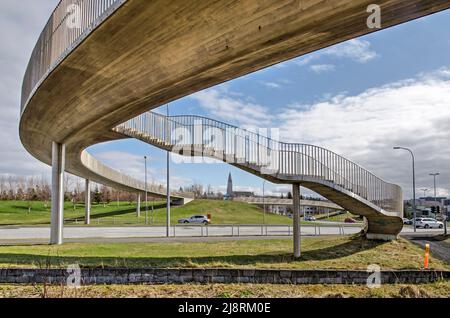 Reykjavik, Iceland, April 25, 2022: curving concrete overpass across Hringbraut road with the iconic Hallgrimmskirkja in the background Stock Photo