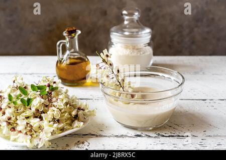 Acacia flowers on plate with batter and dipped branch for cooking fritters  Stock Photo