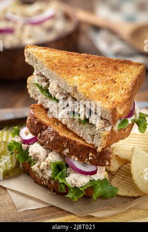 Tuna salad sandwich with lettuce and red onion on toasted wholr wheat bread cut in half and stacked Stock Photo