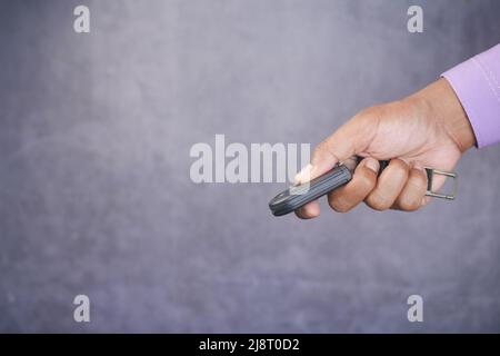 holding a car key and pressing the button  Stock Photo