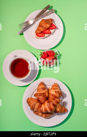 Breakfast with croissants, fresh strawberries, whisked cream and a cup of tea. Stock Photo