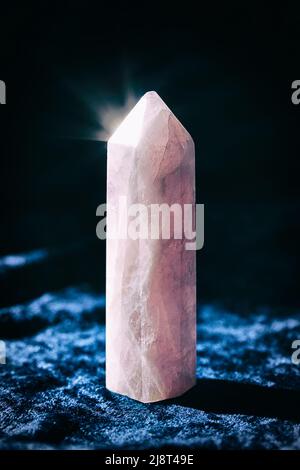 One rose quartz crystal on gray background. Healing minerals, gemstones for relaxation Stock Photo