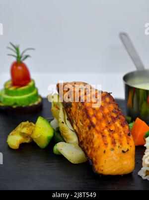 Grilled salmon piece with rice sauce and vegetables Stock Photo