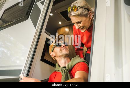 Outdoors and RVing Theme. Caucasian Couple in Their 40s Having Fun In Their Motorhome Camper Van. Vacation Time Camping. Stock Photo