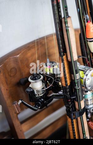 Close up fishing rods stand on wooden chair Stock Photo - Alamy