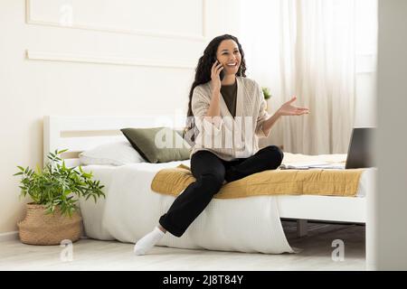 Smiling woman talking on cell phone at home Stock Photo