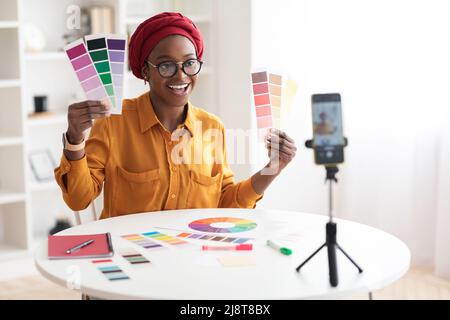 Cheerful black woman fashion designer broadcasting from home Stock Photo