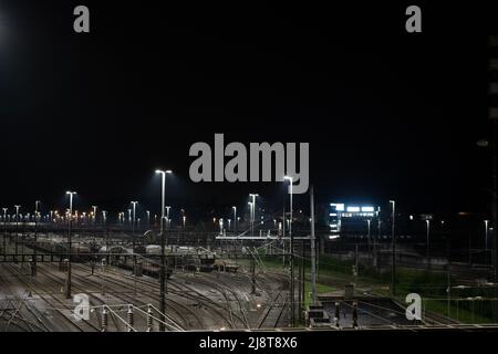 Freight station by night in Zurich, Spreitenbach. Freight trains are illuminated by bright spotlights. Stock Photo