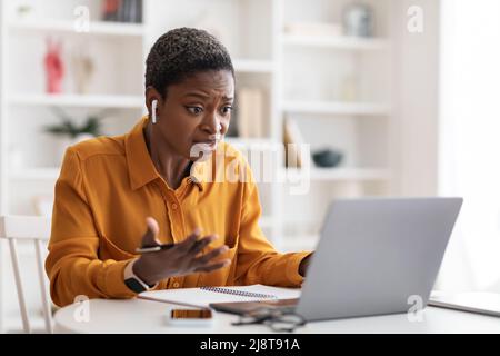 Stressed black lady manager having video chat with colleagues Stock Photo