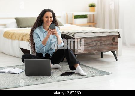 Portrait of smiling woman using smartphone at home Stock Photo