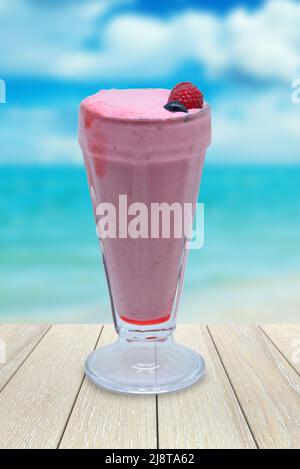 A glass of blueberry juice with berries for decoration on a beach background Stock Photo