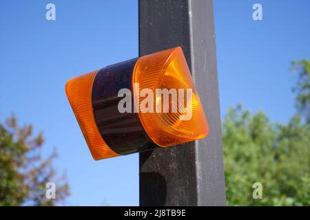 Orange flashing light for remote controlled gate opening system, Hungary Stock Photo