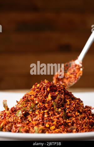 red chili sambol or spicy condiment on a plate with a spoon, made with chili peppers and maldive fish, taken in shallow depth of field, closeup view Stock Photo