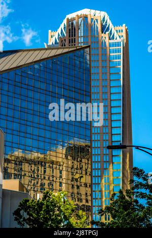Hearst Building in uptown Charlotte, North Carolina on a bright sunny day with brilliant blue sky, a few wispy clouds and  reflections in windows. Stock Photo