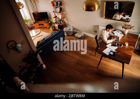 Asian male studying in apartment Stock Photo