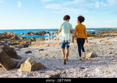 Loving young african american couple holding hands while walking at beach, copy space Stock Photo