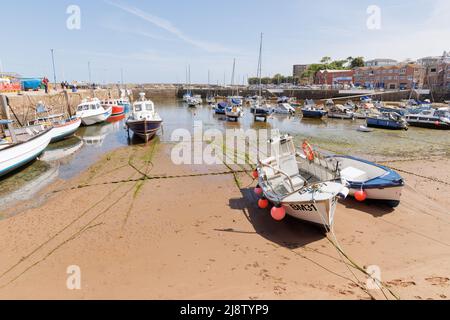 Paignton, Devon, UK, May 14th 2022: The tide is out in Paignton Harbour and the moored small boats rest on the sand. Stock Photo