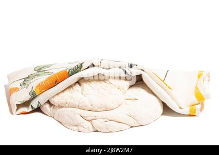 Raw yeast dough covered with a towel. Concept home baking or making dough. Isolated on white background. Stock Photo
