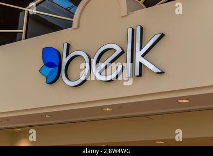 Interior mall 'Belk' department store facade brand and logo signage with windows above, lights below and blue logo. Stock Photo