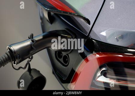 Power cable pump plug in charging power to electric vehicle EV car. Close-up Stock Photo