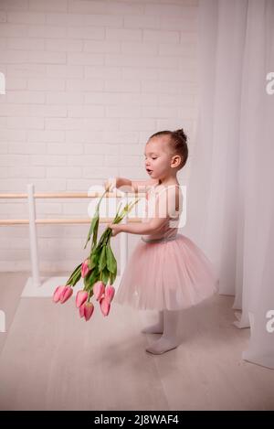 Cute little girl ballerina and her teacher doing exercises in ballet class . child doing ballet Stock Photo