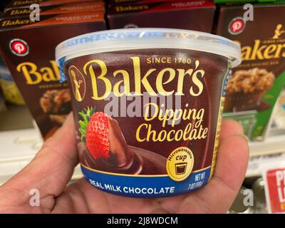 Augusta, Ga USA - 04 15 22: Hand holding Bakers dipping chocolate Stock Photo