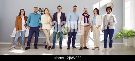 Group of diverse business people in creative office, successful team smiling happily Stock Photo