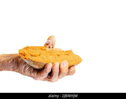 Elderly woman's hand holds out a piece of rye bread on a white background Stock Photo