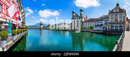 Panoramic view of Lucerne (Luzern) town with famous Chapel wooden bridge over Reuss river and Jesuit Church.  Switzerland travel and landmarks. Stock Photo