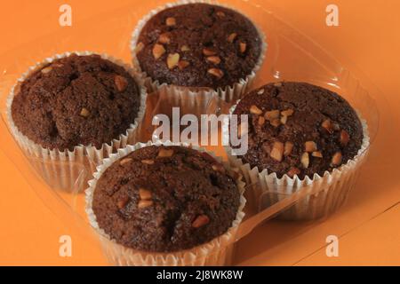 Chocolate muffin isolated on color background. Delicious chocolate muffin with nuts. Stock Photo