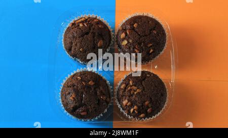 Chocolate muffin isolated on color background. Delicious chocolate muffin with nuts. Stock Photo