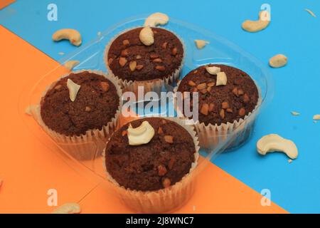 Chocolate muffin isolated on color background. Delicious chocolate muffin with nuts. Stock Photo