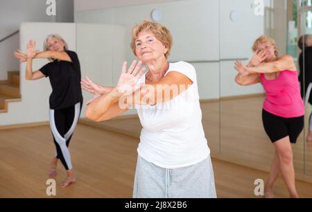 Active elderly lady learning modern dynamic dances in choreography class Stock Photo